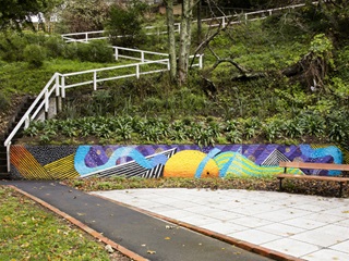 A bright retaining wall with stairs leading up from it.