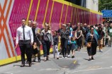 People walking alongside the Civic precinct hoarding.