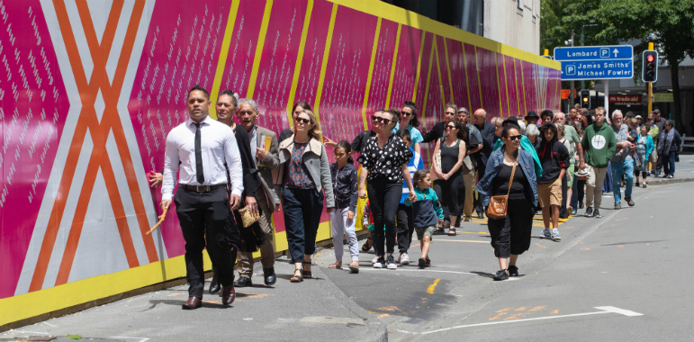 People walking alongside the Civic precinct hoarding.