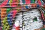 Close up: mural showing books, multi-coloured knitted blanket, coffee flask.