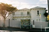 In situ: Bus shelter with bright-coloured geometric shapes in front of house.