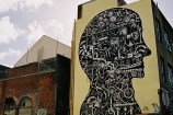 Black and white mural in illustrative style showing projector parts and forming a head shape.