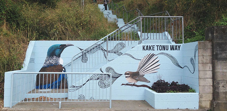 Kereru / wood pigeon and fantail on light blue background with black swirls.