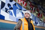 Wharehoka Smith in front of his mural.