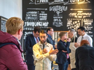 A man dressed up as a barber talking to a crowd.