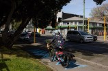 Person riding bike along the bike network, on the footpath are the blue markings to signify the awa that was there.