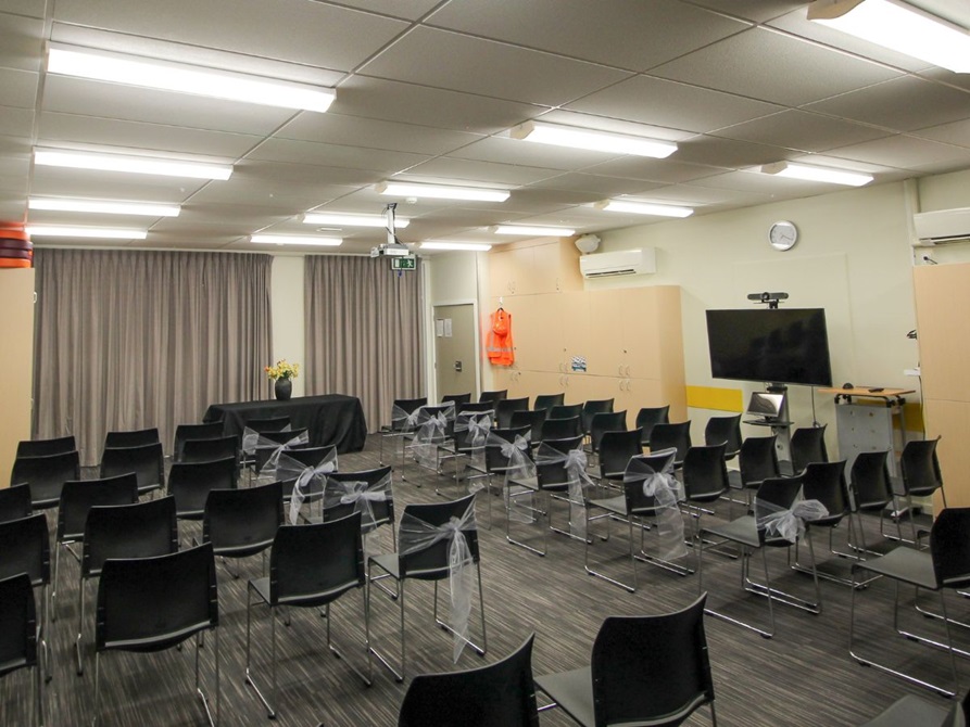 Room with chairs split in two sides with an aisle in the centre.