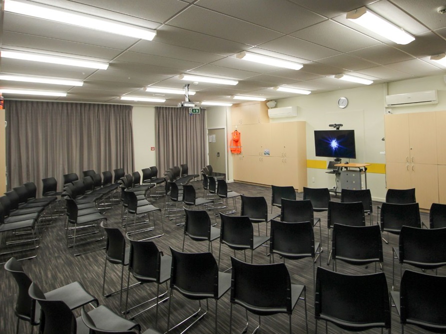  Room with chairs, a TV and a podium.