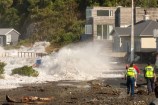 A large wave crashes onto the shore at Ōwhiro Bay.