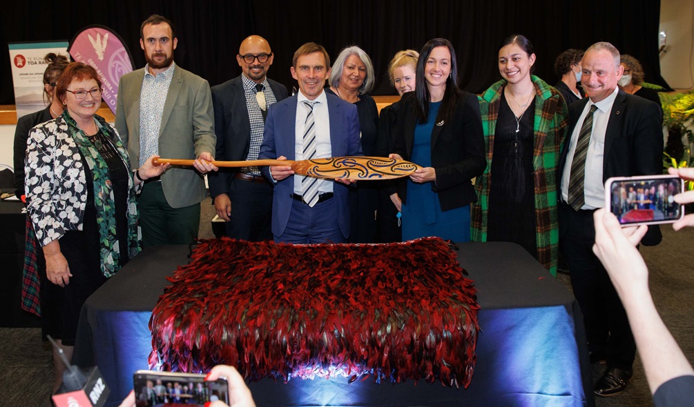 Signatories pose with hoe (paddle).