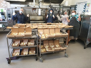 Image of team at the Compassion Soup Kitchen preparing food packages