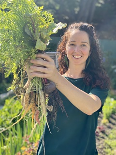 Image of Elza van Boxel of Seeds to Feeds holding fresh vegetables. 