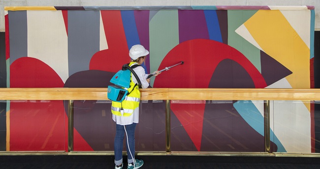 A large textile artwork by Gordon Crook being cleaned. 
