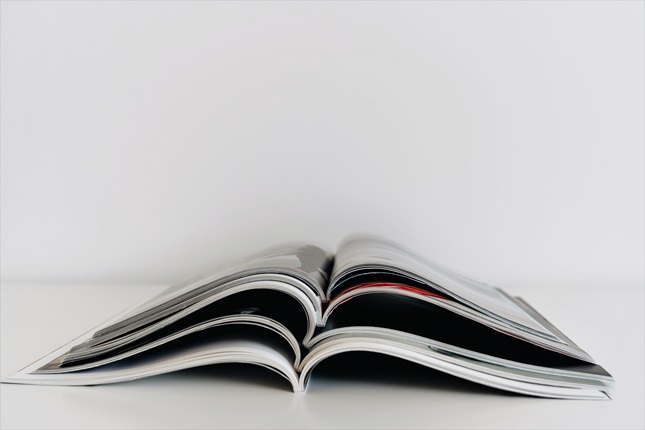 A stack of five open magazines on a white background.