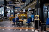 A group of blue desk chairs sit scattered around an abandoned desk near the entrance to the Central Library.