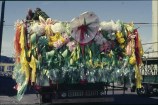 A large colourful float made up of lots of flowing fabric and fake flowers.