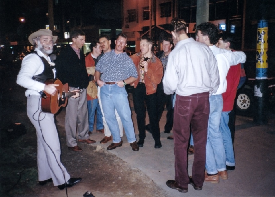 John Adams aka Kenny the Busker surrounded by revellers on Courtenay Place