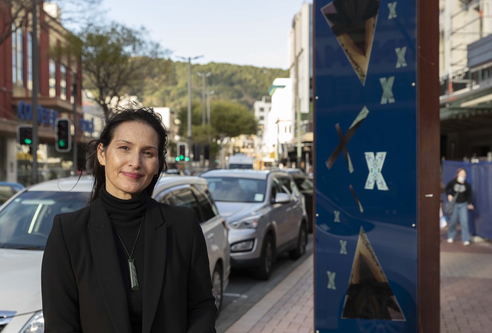 Woman standing on the street in front of her art.