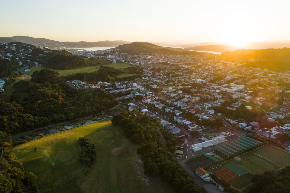 An aerial shot of the city with sun glare shining in the corner.