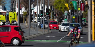 Cyclist on a bike and cars on the street. 