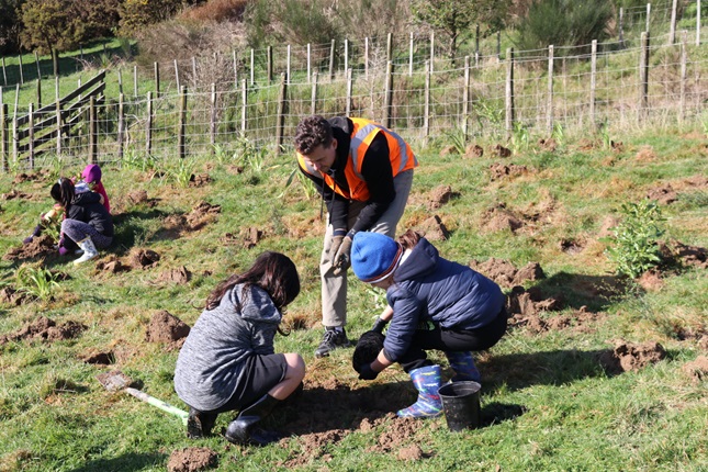 Kids planting with a staff member