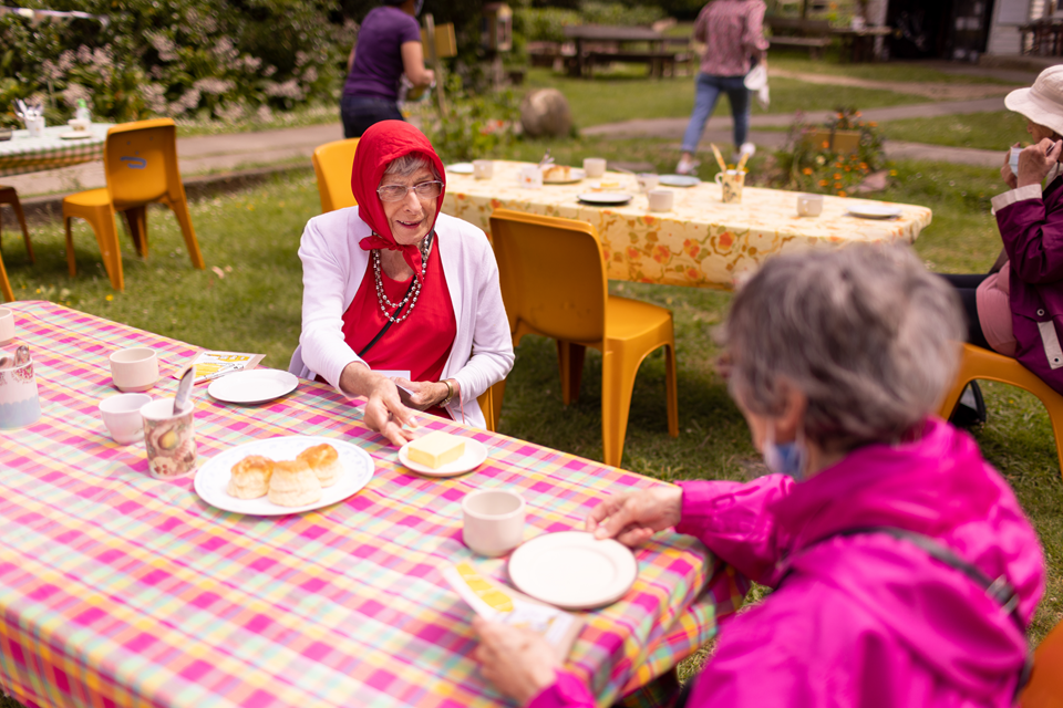 Two women enjoy tea and scones at Seniors' Week event at Innermost Gardens