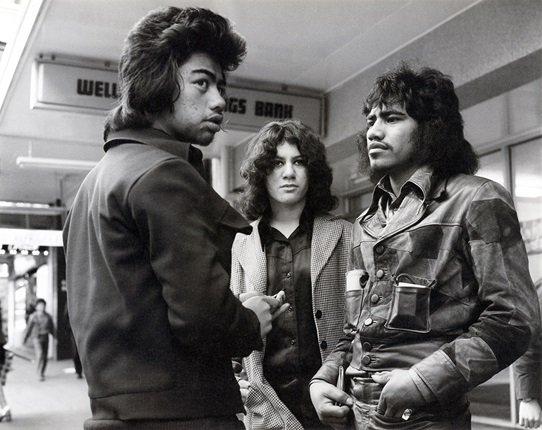 Three people standing on the street.