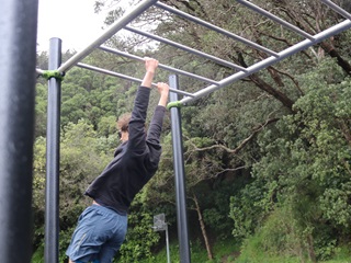 Man dangling from monkey bars.