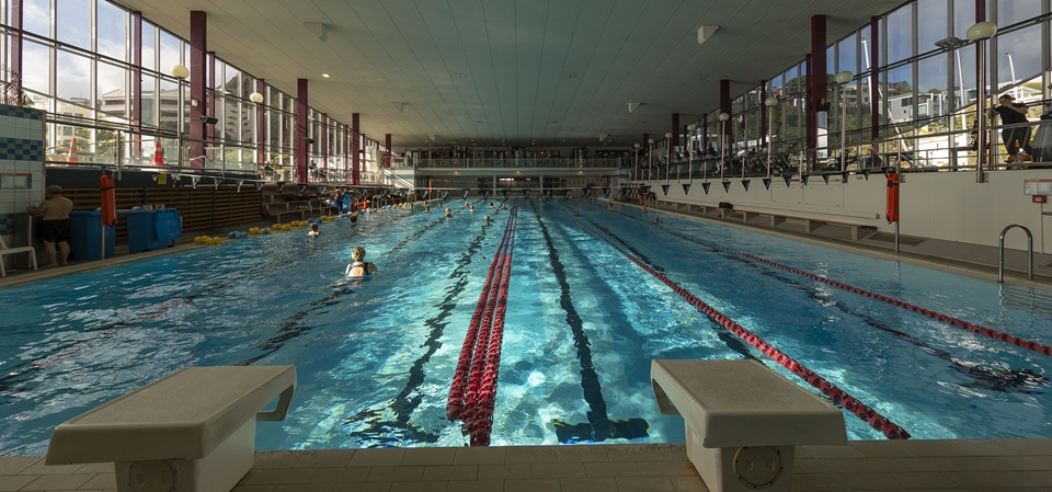 Landscape from one end of Freyberg pool looking towards the deep end with sun shining through windows.