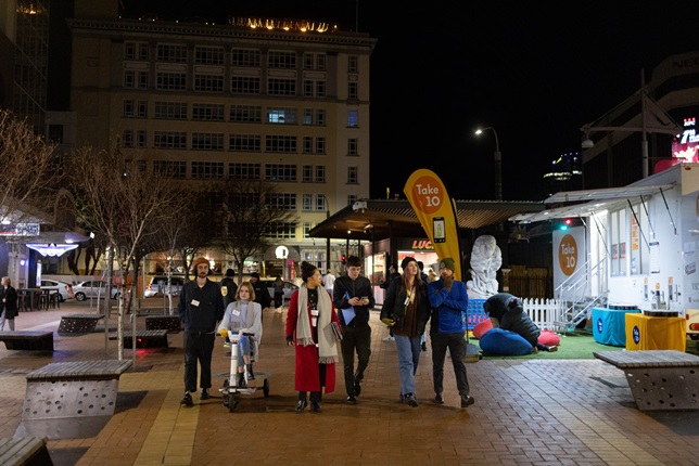 Group of six people walking down Courtenay Place in Wellington.
