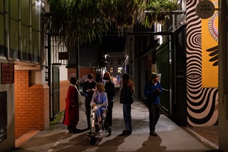 Group of six people walking down an alley.