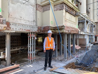 Person standing outside of the town hall wearing safety gear.