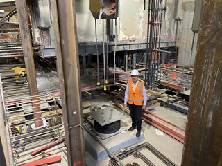 Person standing inside of the town hall wearing safety gear.