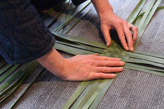 Someone weaving a pattern.