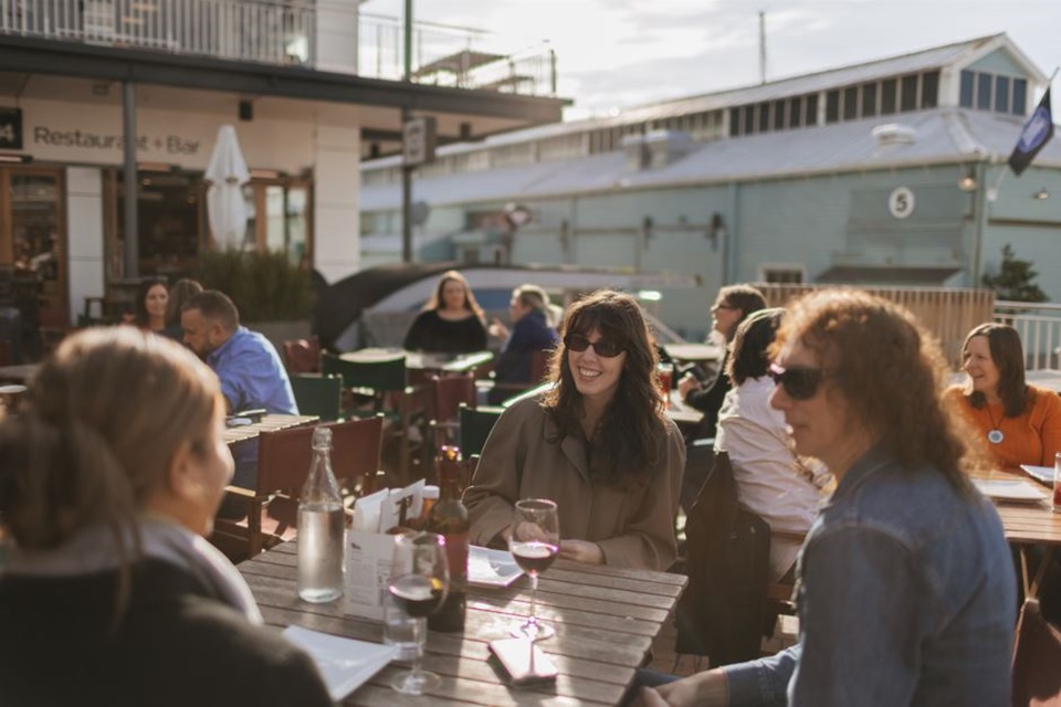 Group of people sitting in an outdoor bar on Queens Wharf