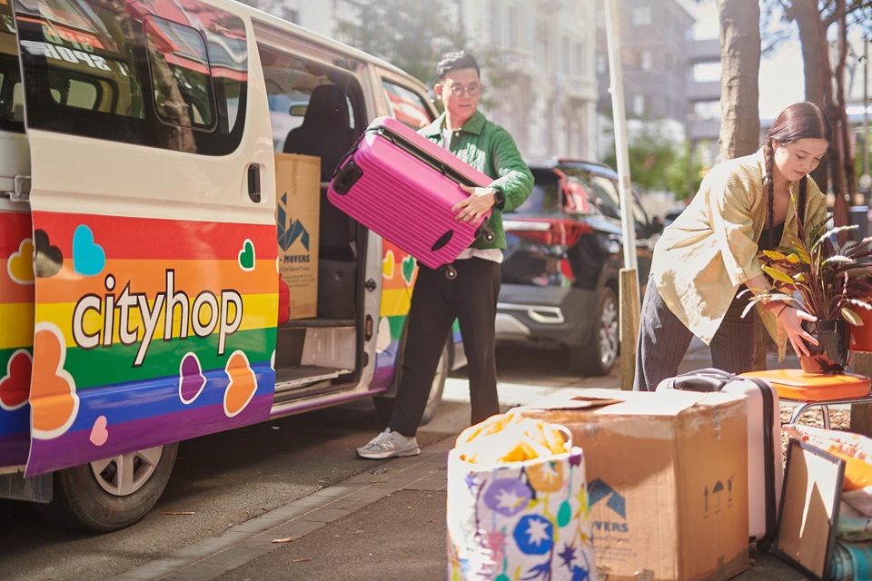 Two young people moving house items using car sharing service.