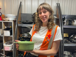 Woman holding cookware.