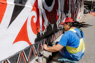 Ariki Brightwell painting her mural.