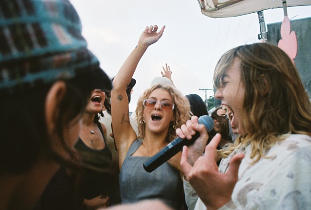 People dancing and singing in a crowd.