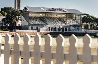 Fence with a grandstand in the background.