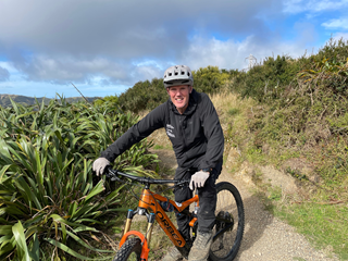 Man sitting on top of an ebike in the mountains.