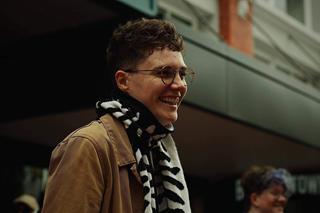 Person wearing a mustard yellow jacket with a scarf.