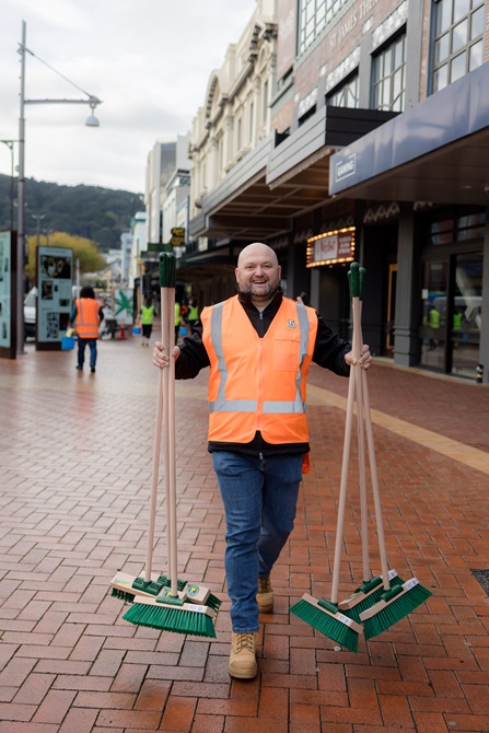 Person holding brooms.
