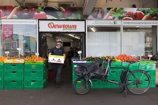 Person carrying a delivery box to an ebike.