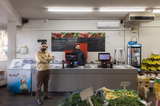 Two people standing inside of a Greengrocer in Newtown.