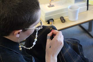 A person repairing an item of clothing.