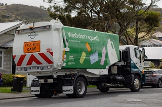 Rubbish and recycling truck parked on the side of the road.