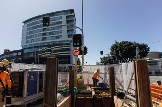 Workers at a construction site with buildings in the background.