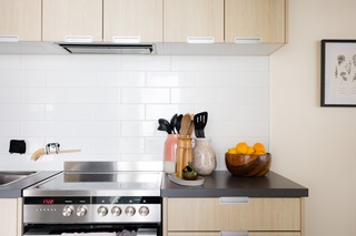 Kitchen with brown shelves and a bowl of citrus sitting on the bench.