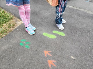 Spray painted hands and feet on the ground.